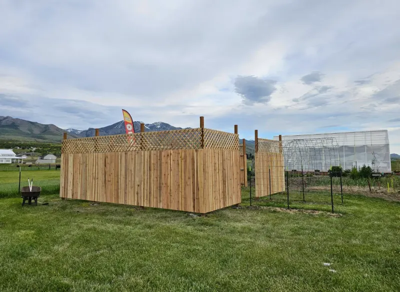 Completed cedar privacy fence with lattice top enclosing a garden in Cache Valley