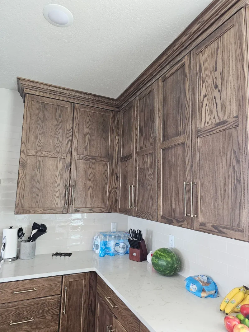Stained oak upper kitchen cabinets after the hardware install