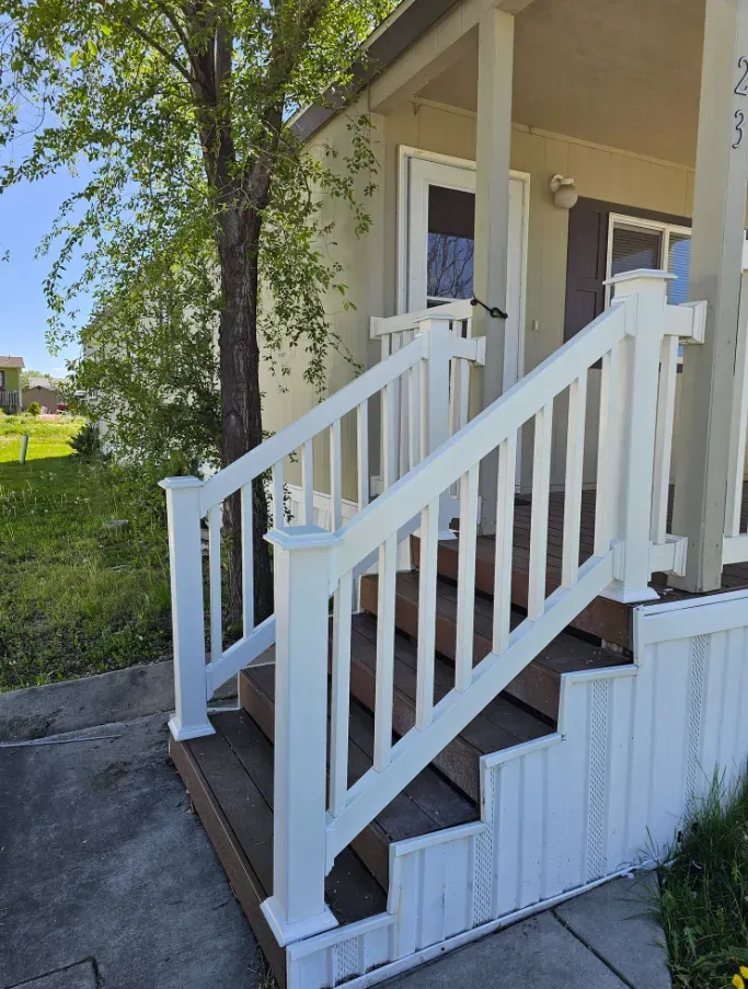 Finished white porch railing and steps at a home entrance