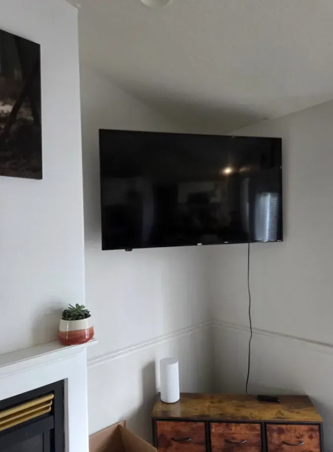 Flat-screen TV mounted on the wall above a fireplace